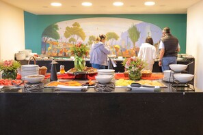 En buffet med forskellige retter og et maleri på væggen.