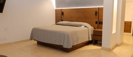 A modern bedroom with a bed, bedside tables, and a wooden headboard.