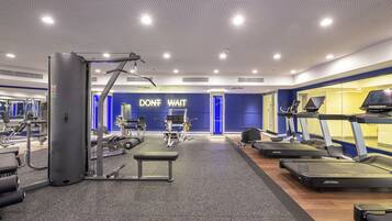 A gym with treadmills, weight machines, and a motivational wall.