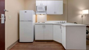 A compact kitchen with white cabinets, a microwave, and a refrigerator. - Extended Stay America Suites Santa Rosa North (Santa Rosa)