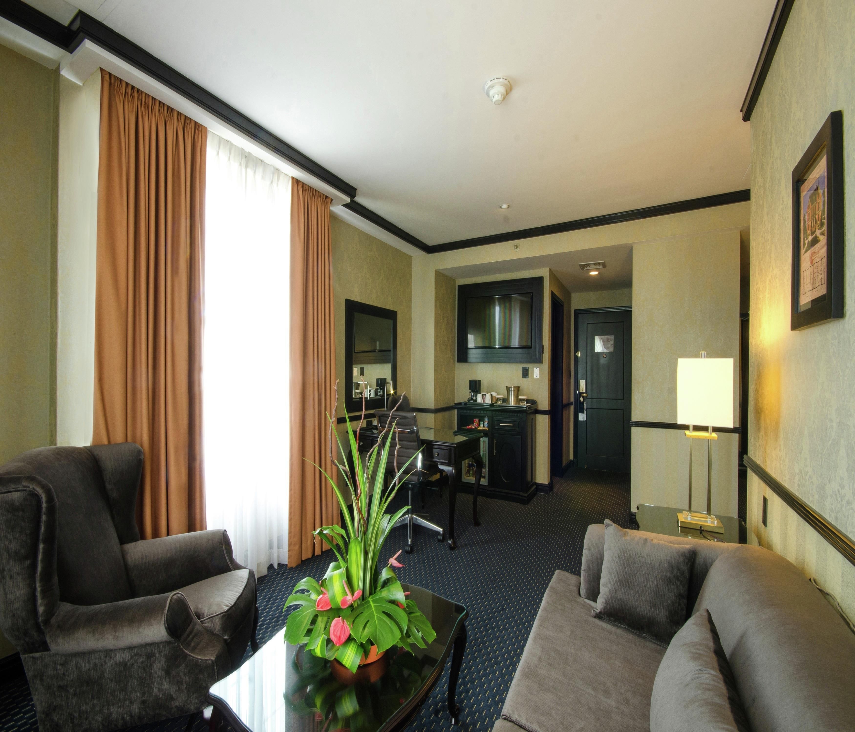 Une chambre d’hôtel comprenant un coin salon, une table à manger et une kitchenette.