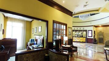 A hotel lobby with a reception desk, seating area, and a reception counter.