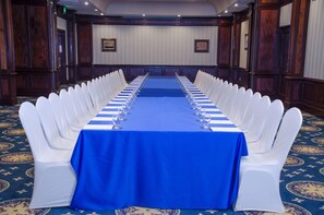 A conference room with a long table, white chairs, and a blue tablecloth. - Hilton Princess San Pedro Sula (San Pedro Sula)