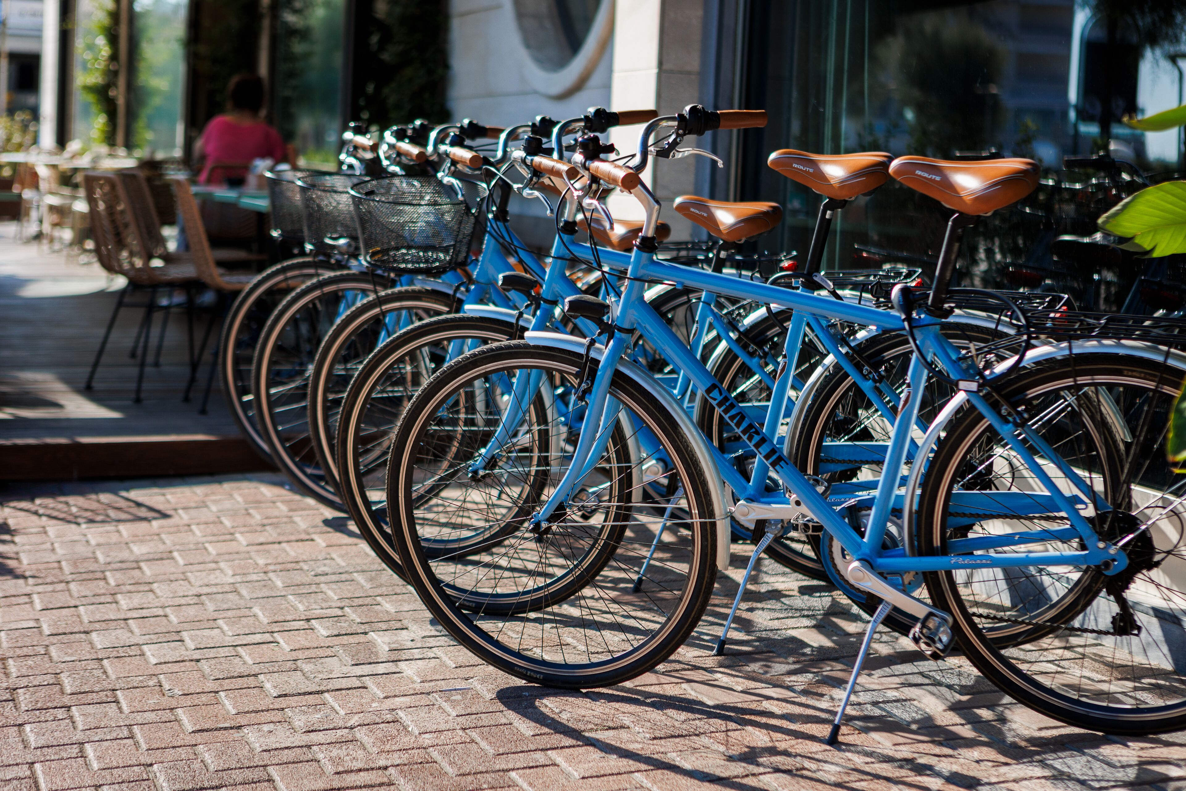 Una fila de bicicletas azules estacionadas sobre un pavimento de ladrillo.