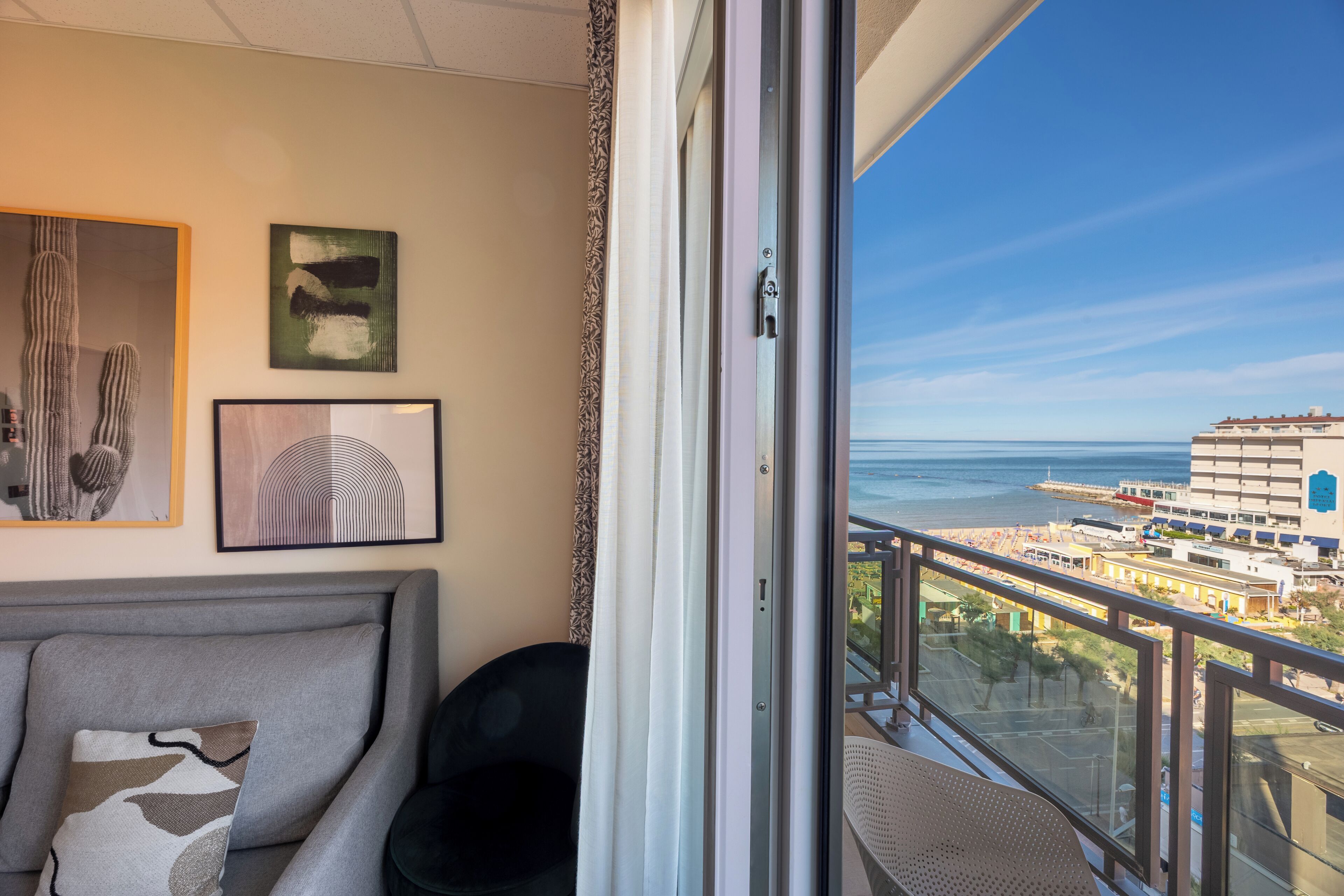 Ein Balkon mit Blick auf das Meer und die Gebäude.