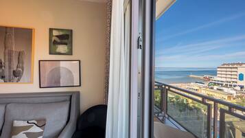 A balcony with a view of the sea and buildings.