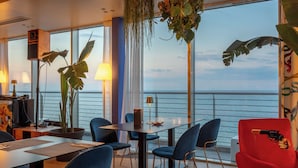 Un comedor moderno con una mesa grande, sillas azules y plantas en macetas.