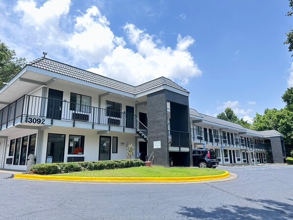 A multi-story hotel with a modern design, featuring balconies and a parking area. - Masters Inn Atlanta - Doraville at I-85 & 285 (Doraville)