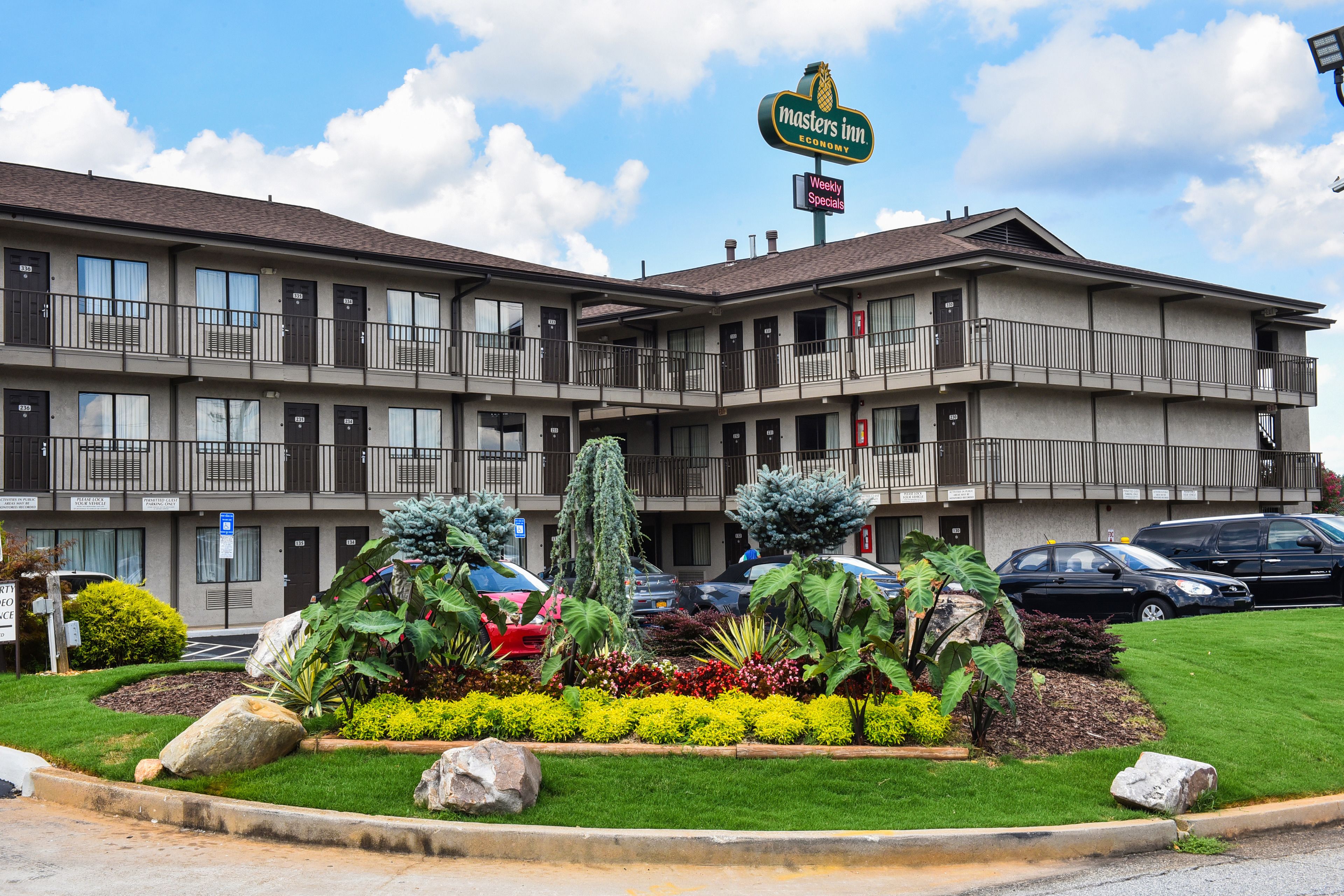 Een meerlaags motel met een bord waarop 'Masters Inn Economy' staat.