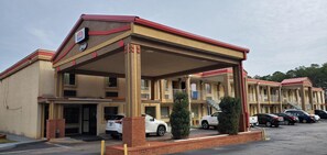 Guests can park their vehicles under the covered area of this two-story motel.