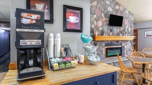 Uma estação de café com máquina de café, xícaras e um aviso de café fresco.