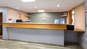 A reception desk with a wooden counter, a sign reading "American Inn," and a map on the wall.