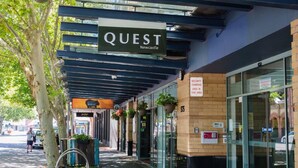 En overdækket gangbro med et skilt, der viser "QUEST Newcastle".