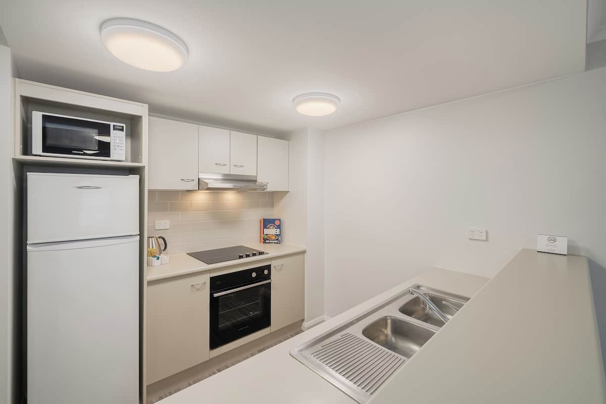 Una cocina compacta equipada con microondas, horno y lavamanos.