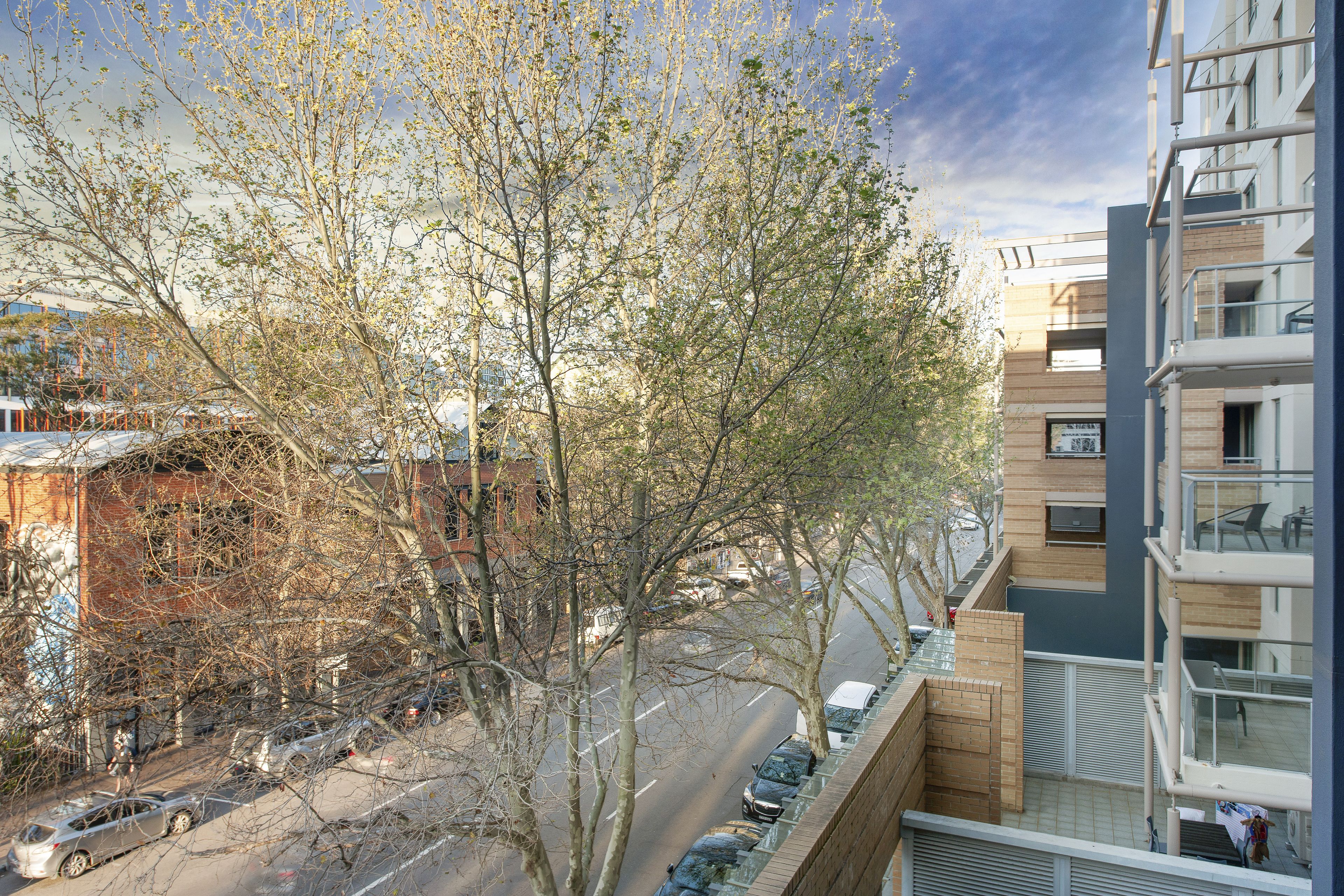 A multi-story building with a modern architectural design, featuring balconies and large windows.