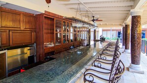 A kitchen with wooden cabinets, a stainless steel oven, and a marble countertop. - Windward Passage Hotel (St. Thomas)