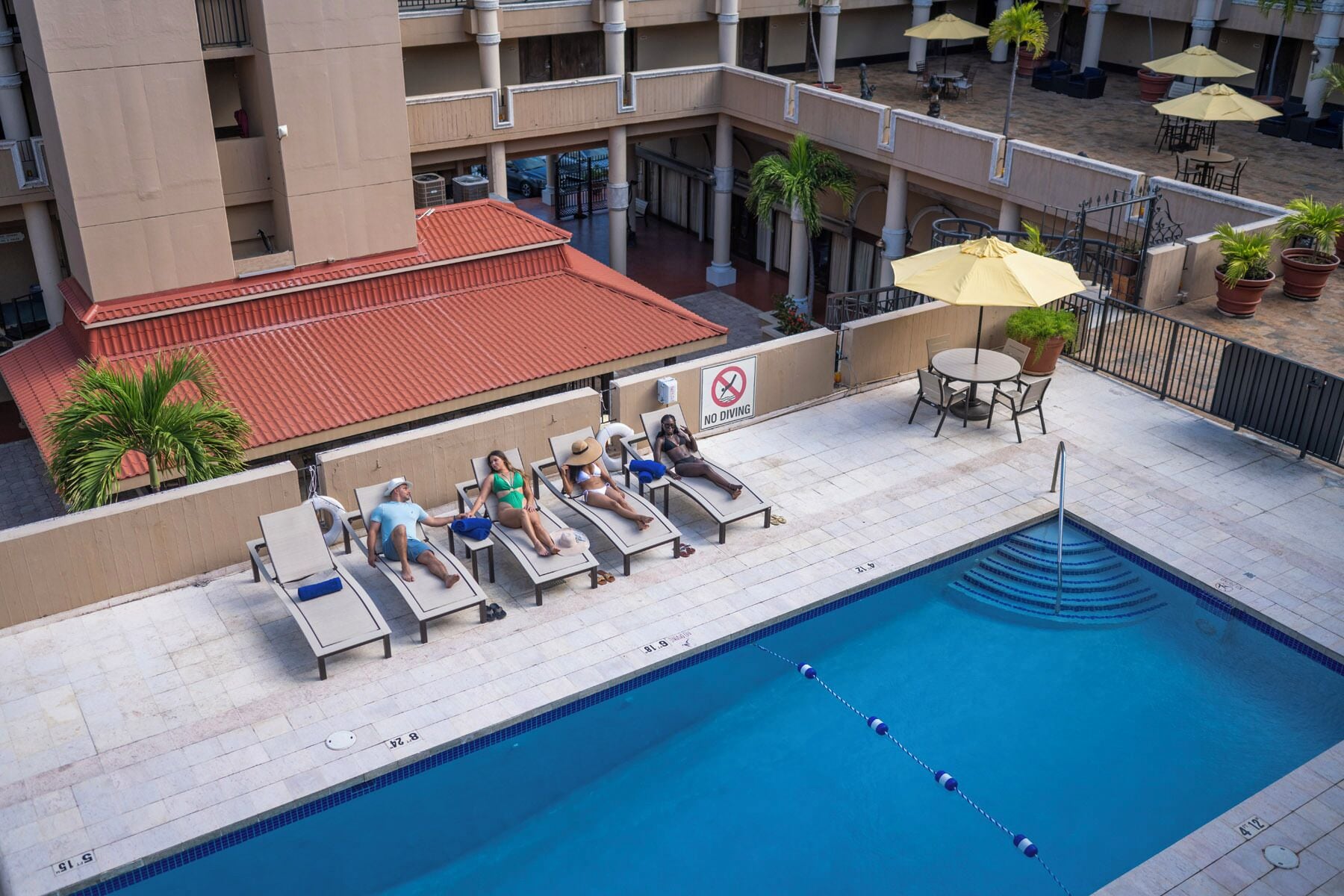 A poolside area with lounge chairs and a 'No Diving' sign.
