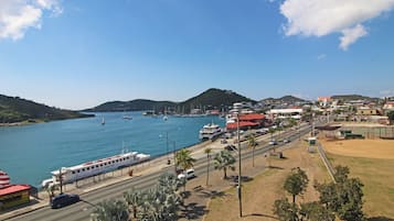 A coastal town with a marina, boats, and a road with vehicles.