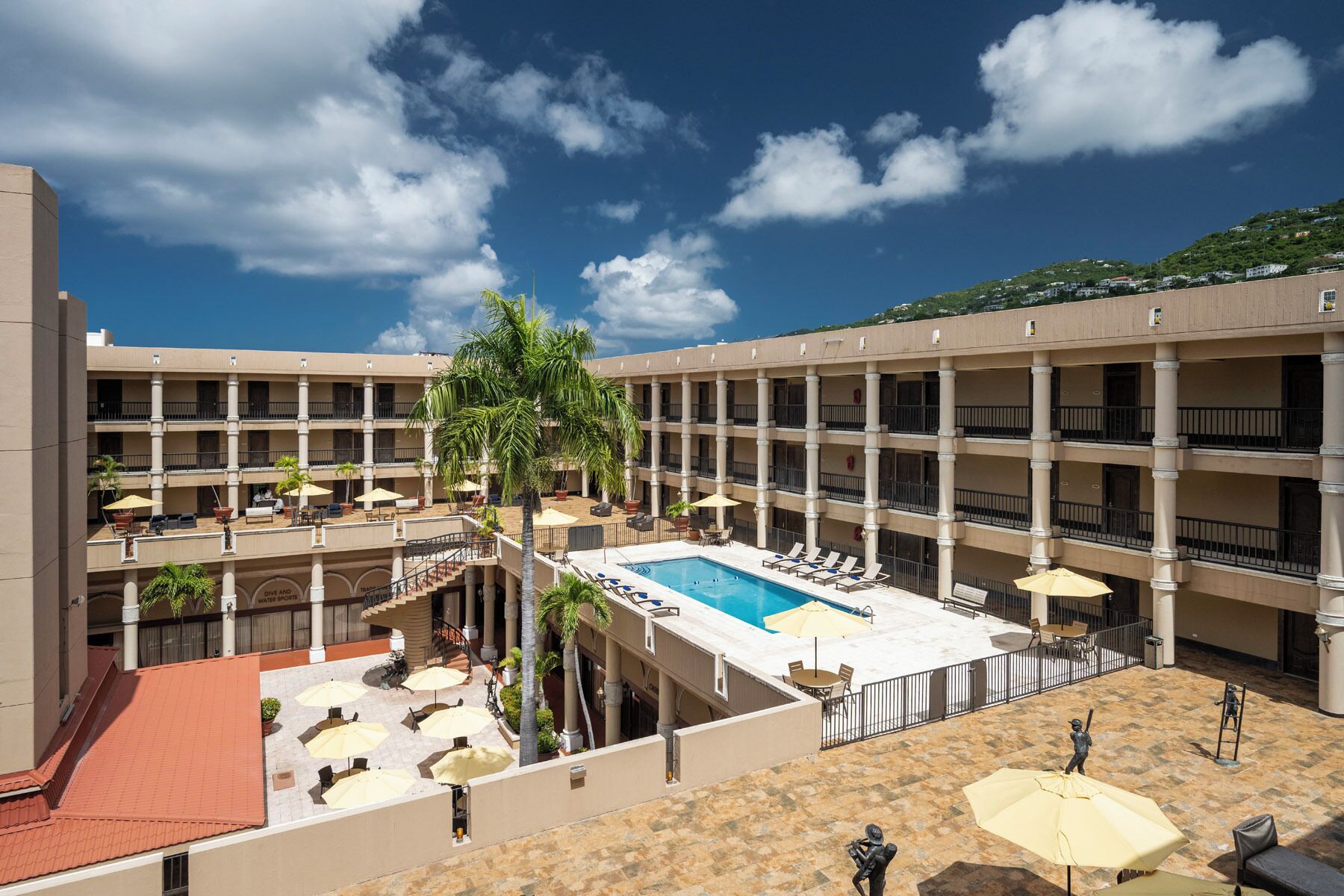 Un hôtel doté d’une piscine centrale, de nombreux balcons et d’espaces extérieurs aménagés pour se détendre.