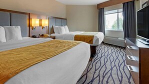 A hotel room with two beds, a TV, a desk, and a window with curtains. - Comfort Inn & Suites Market - Airport (Great Falls)