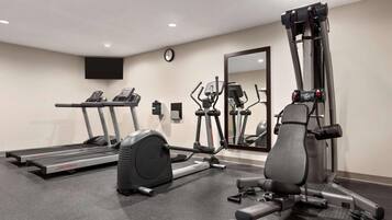 Un gimnasio con cintas de correr, elípticas y máquinas de pesas.