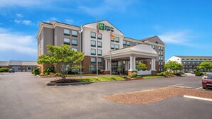 A Holiday Inn Express hotel with a central entrance, flagpoles, and a landscaped area. - Holiday Inn Express Hotel & Suites Ocean City by IHG (Ocean City)