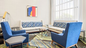 A modern living room with a sofa, two armchairs, a coffee table, and a patterned rug. - Holiday Inn Express Hotel & Suites Ocean City by IHG (Ocean City)