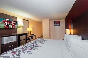 A hotel room with a bed, a TV, a desk, and a microwave. - Red Roof Inn Valdosta - University (Valdosta)