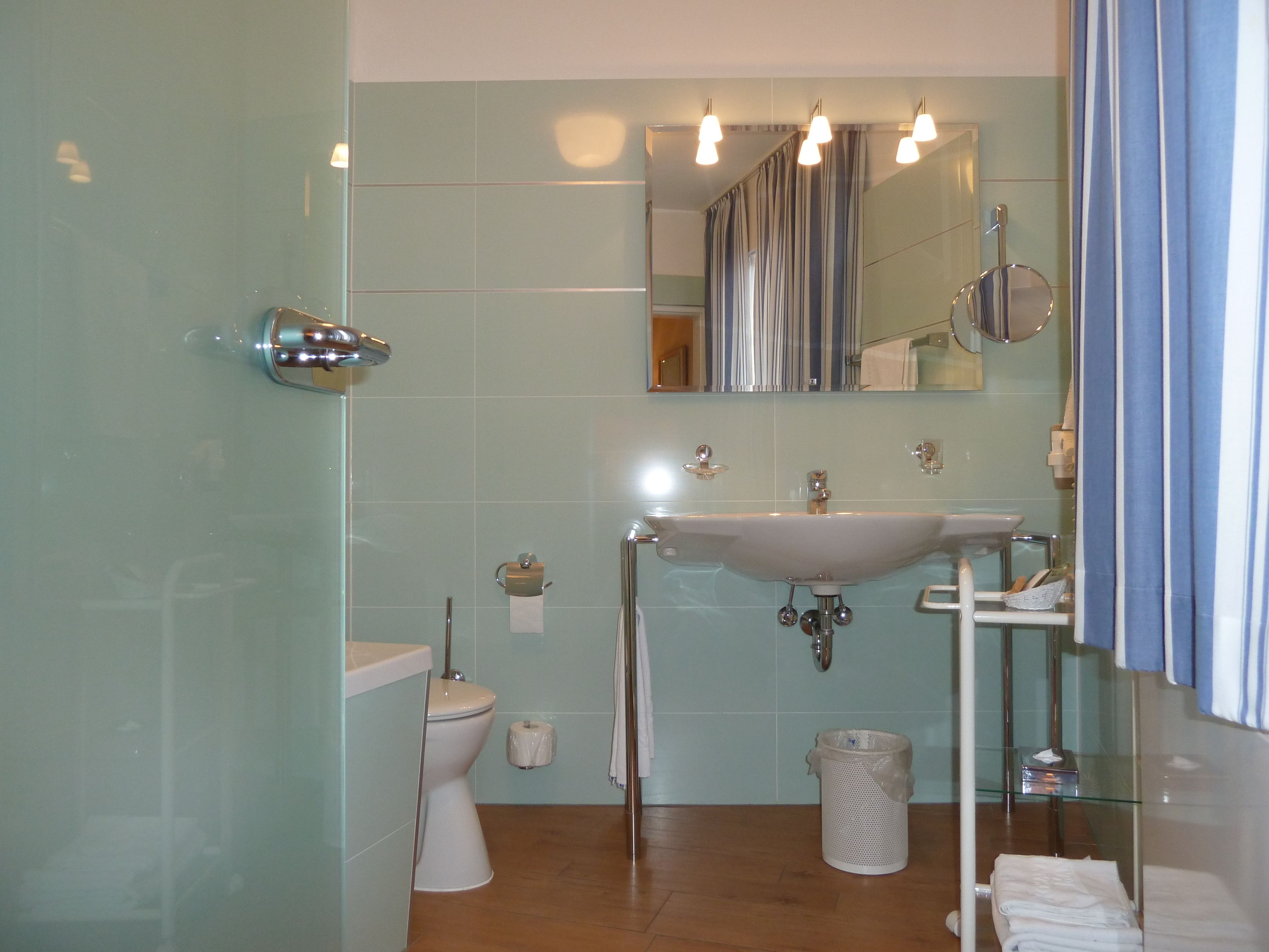 A bathroom with a toilet, sink, and shower.