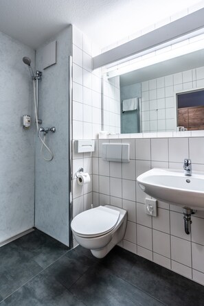 Ein modernes Badezimmer mit Dusche, Toilette und Waschbecken.
