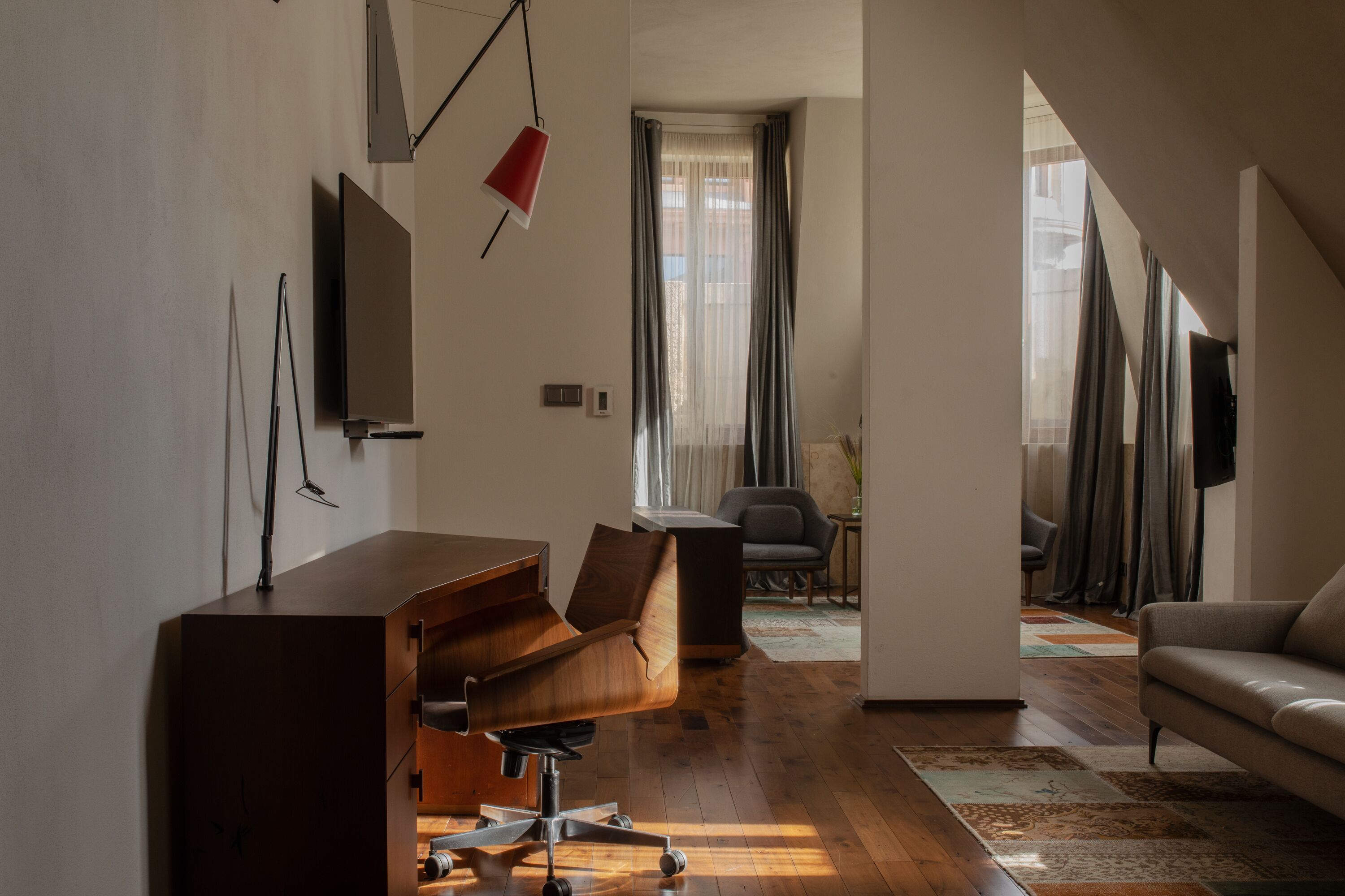 Una sala de estar moderna con un escritorio de madera, un sofá cómodo y una televisión.