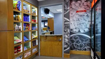 A snack bar with shelves stocked with various snacks and a wall with a 'Treats' sign.
