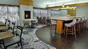 Eine moderne Hotelhalle mit Kamin, Essbereich und Bar/Lounge-Bereich.