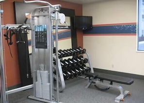 Stay fit and active with a range of exercise equipment, including a cable machine, dumbbells, and a bench, plus a TV for entertainment.