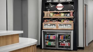 A vending machine with snacks and drinks, a wooden counter, and a sign above it. - Hampton Inn Butte (Butte)