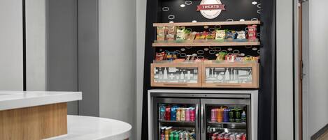 Un distributeur automatique de collations et de boissons, un comptoir en bois et une enseigne au-dessus.