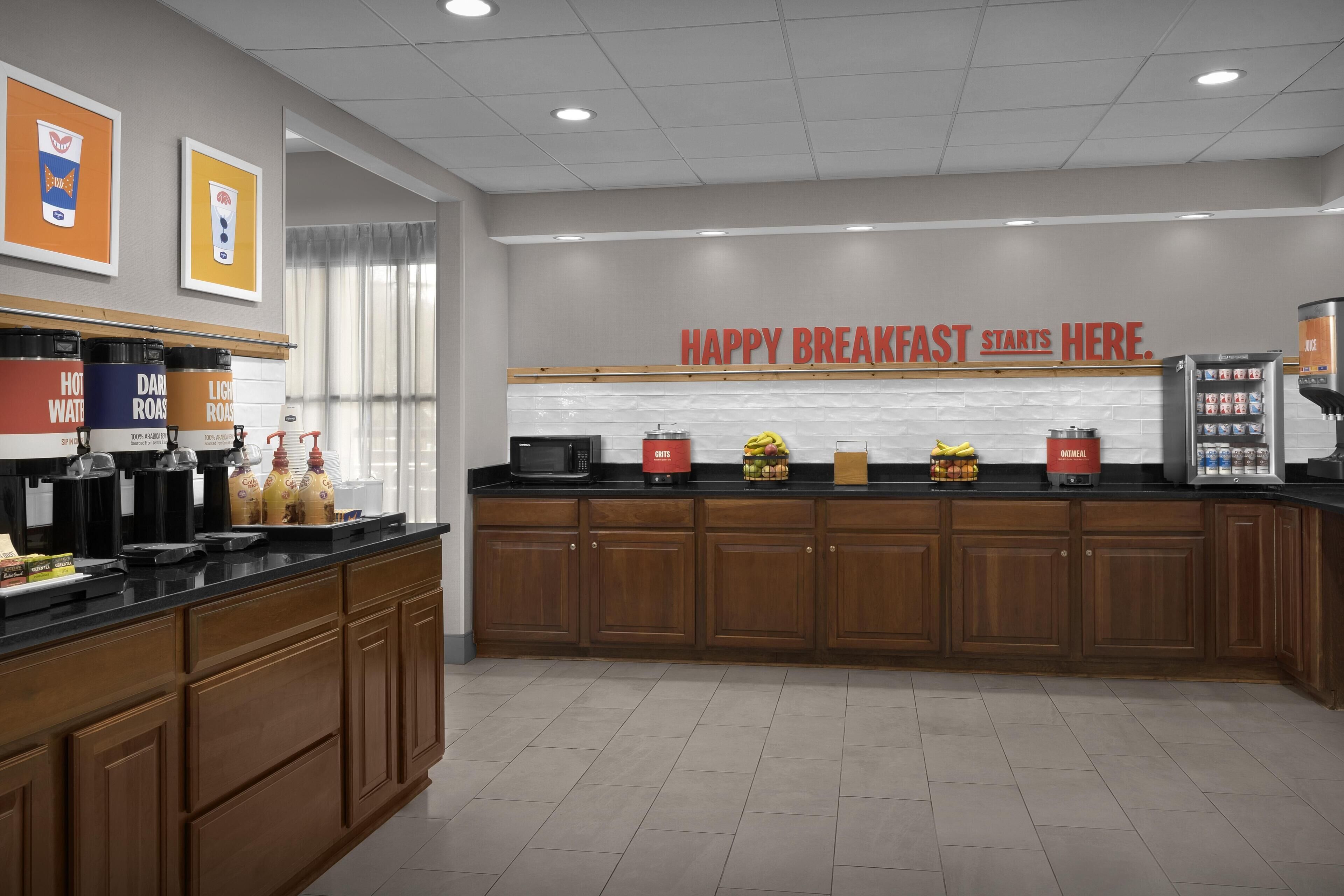 A modern kitchen with a breakfast bar, coffee machines, and a message on the wall.