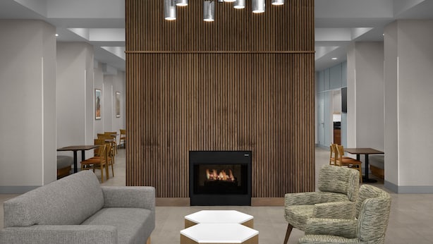 A modern interior with a fireplace, seating, and a wooden wall. - Hampton Inn & Suites Greenville/Spartanburg I-85, SC (Duncan)