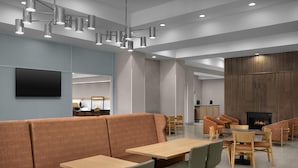 A modern interior with seating areas, tables, a flat-screen TV, and a fireplace. - Hampton Inn & Suites Greenville/Spartanburg I-85, SC (Duncan)