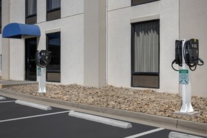 Una estación de carga para vehículos eléctricos, con un cartel que indica que es solo para estacionamiento de coches eléctricos durante la carga.
