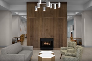 Un interior moderno con chimenea, asientos y una pared de madera decorativa.