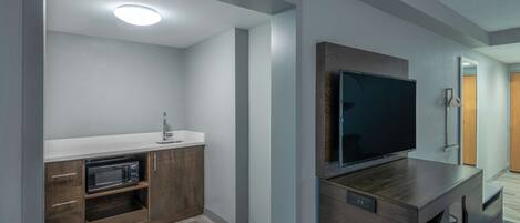 A modern kitchen with a microwave, sink, and wooden cabinets.