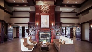 A spacious lobby with a fireplace, wooden flooring, and a chandelier. - Hampton Inn & Suites Dallas-DFW Airport North-Grapevine (Grapevine)