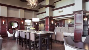 A spacious kitchen with a central island, wooden cabinetry, and pendant lighting. - Hampton Inn & Suites Dallas-DFW Airport North-Grapevine (Grapevine)