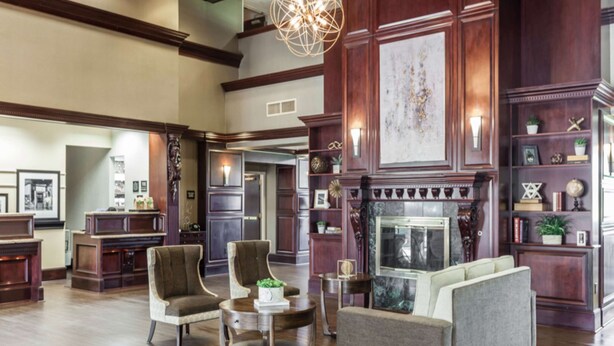 A spacious lobby with a high ceiling, wooden paneling, a fireplace, and a modern chandelier. - Hampton Inn & Suites Dallas-DFW Airport North-Grapevine (Grapevine)