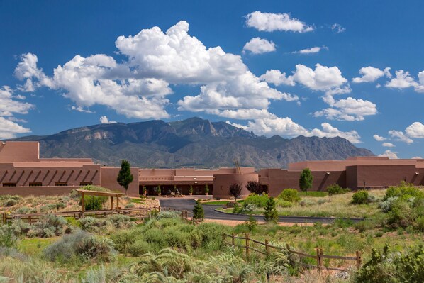 A building with a flat roof and a large parking area in front.