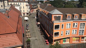 A street view with buildings, outdoor seating, and a café. - Hotel Lindenufer (Berlin)