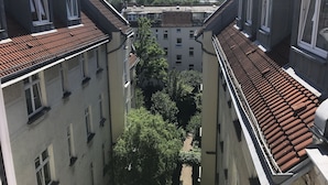 A narrow street between buildings with red-tiled roofs and white window frames. - Hotel Lindenufer (Berlin)
