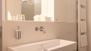 A modern bathroom with a white sink, mirror, and toilet. - Hotel Lindenufer (Berlin)