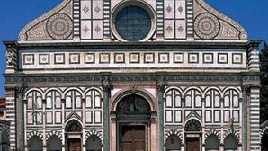 A historic building with a symmetrical facade, arched windows, and a central circular window.